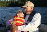 Picture of a Grandfather and Granddaughter on a boat wearing life jackets