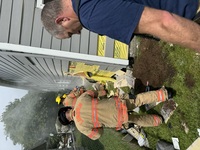 Firefighters use a chainsaw to access the trapped victim.