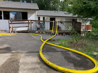 Front of the home showing fire hoses